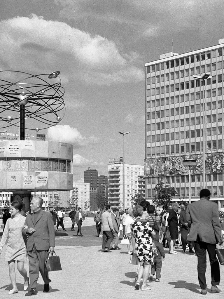 Historische Schwarzweiß-Aufnahme vom Alexanderplatz mit der Weltzeituhr kurz nach der Aufstellung 1969. Die Uhrenanlage mit einer symbolischen Weltdarstellung im Berliner Ortsteil Mitte enthält auf ihrer metallenen Rotunde die Namen von 148 Städten. 