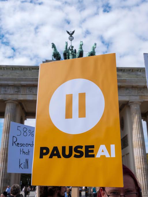 "PAUSE AI" steht auf einem Schild von Demonstranten am Brandenburger Tor "PAUSE AI" steht auf einem Schild von Demonstranten am Brandenburger Tor
