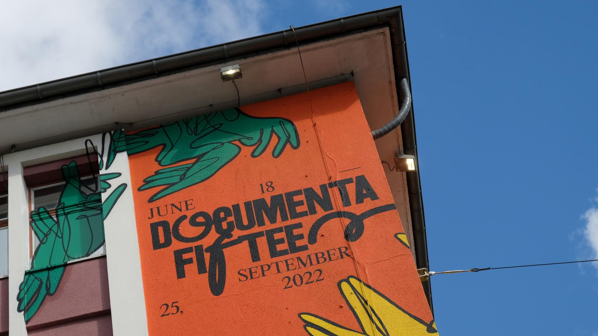 Der Schriftzug "documenta fifteen" und das Logo des indonesischen Kuratorenkollektivs Ruangrupa prangt an einer Fassade