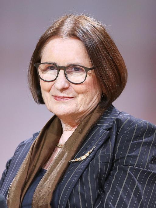 Die russische Publizistin Irina Scherbakowa im Porträt. Sie trägt einen gestreifte blaugrauen Blazer mit braunem Schal, eine Brille und hat braune kurze Haare. 