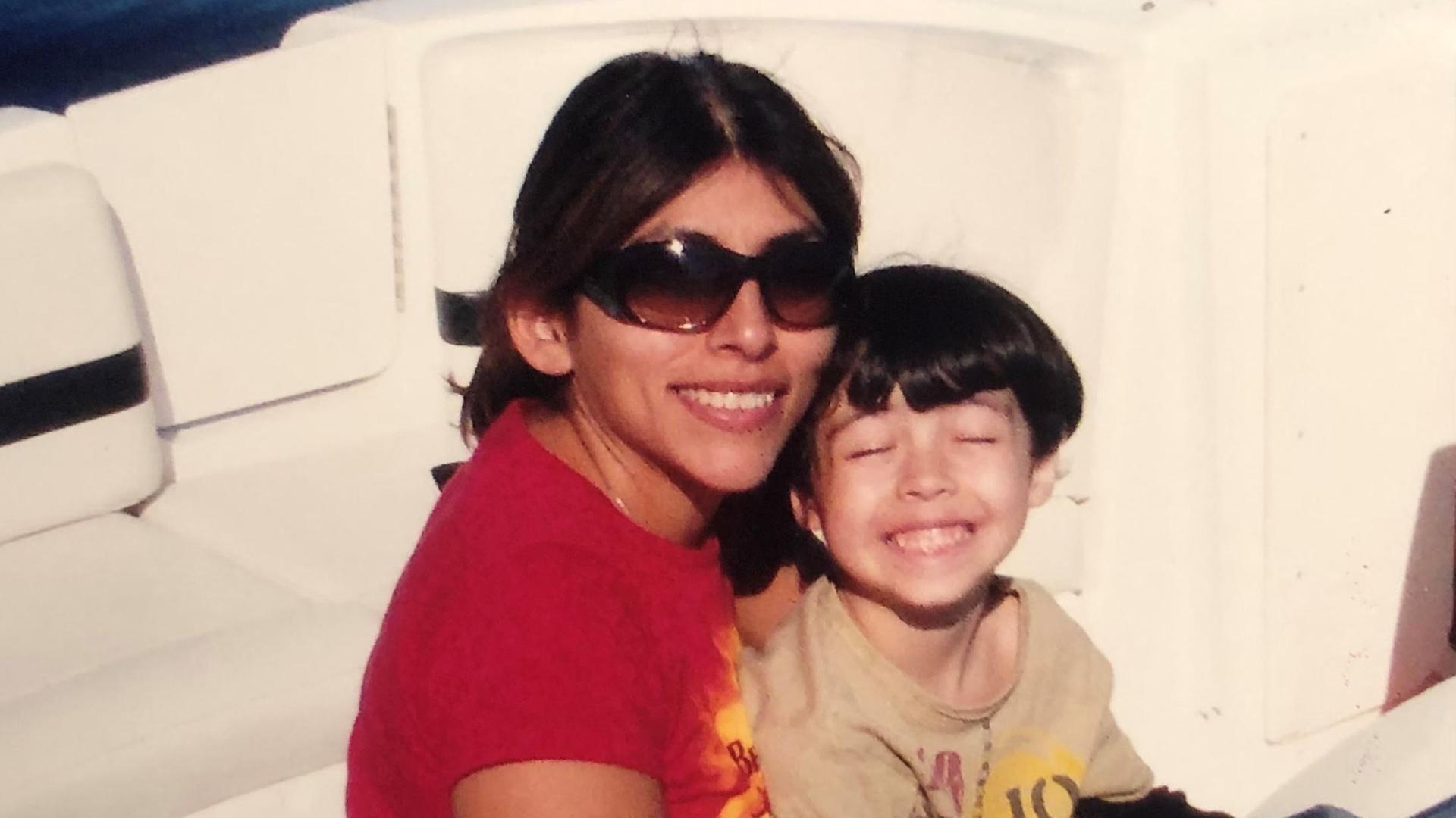 Mutter Gina mit Sonnenbrille und Sohn Aidan auf einem Boot.