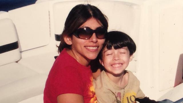 Mutter Gina mit Sonnenbrille und Sohn Aidan auf einem Boot.