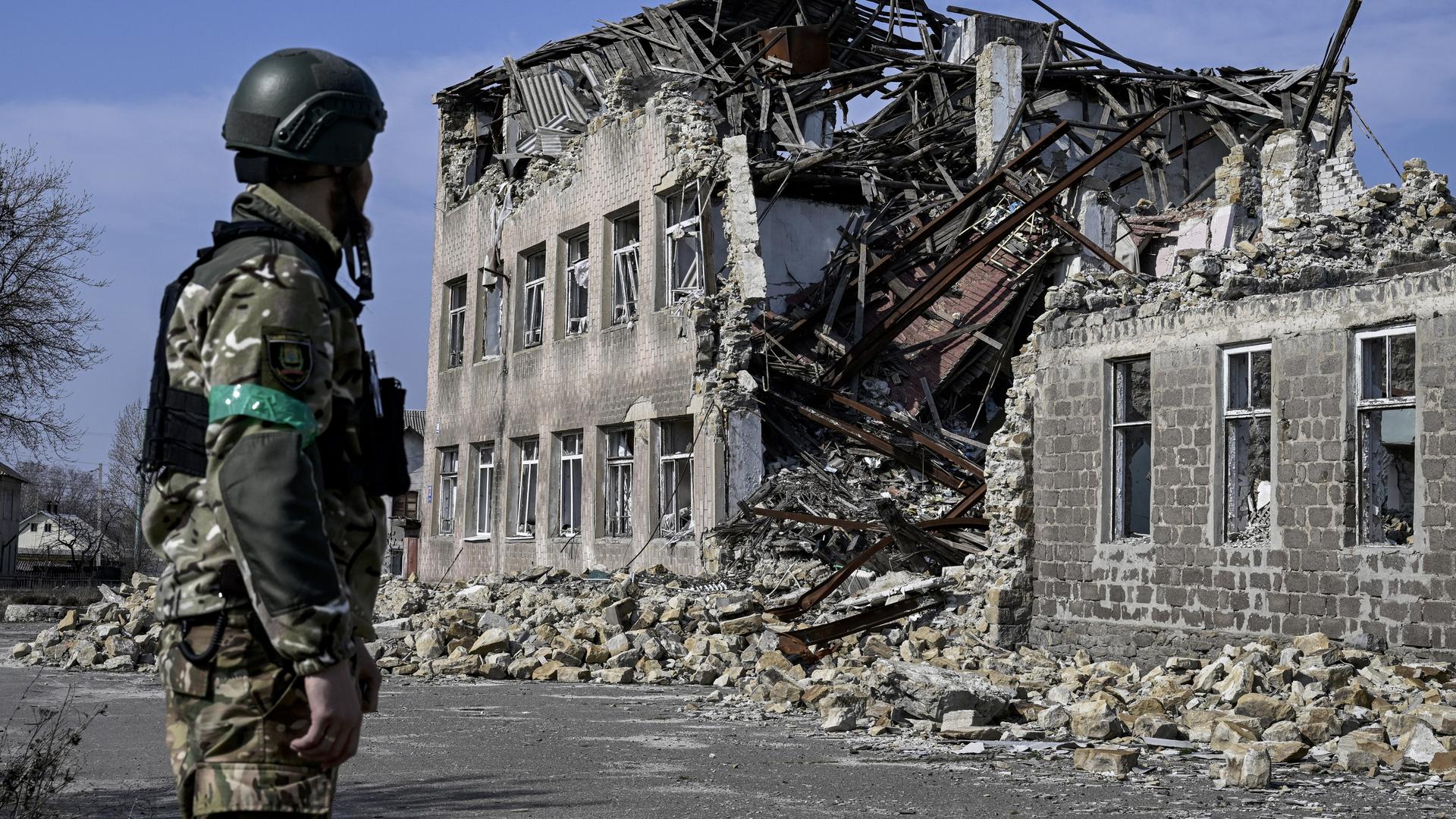 Ein ukrainischer Soldat blickt auf ein zerstörtes Gebäude in der ukrainischen Stadt Toretsk. 