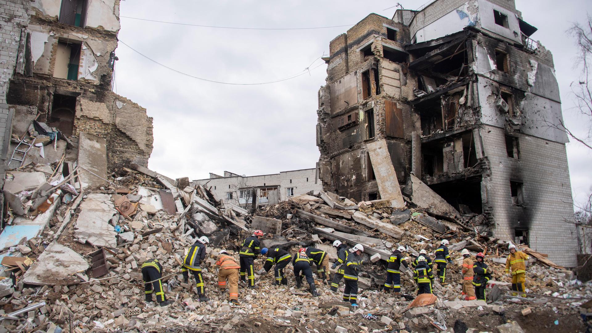 Freiwillige suchen nach Überlebenden in den zerbombten Häusern.