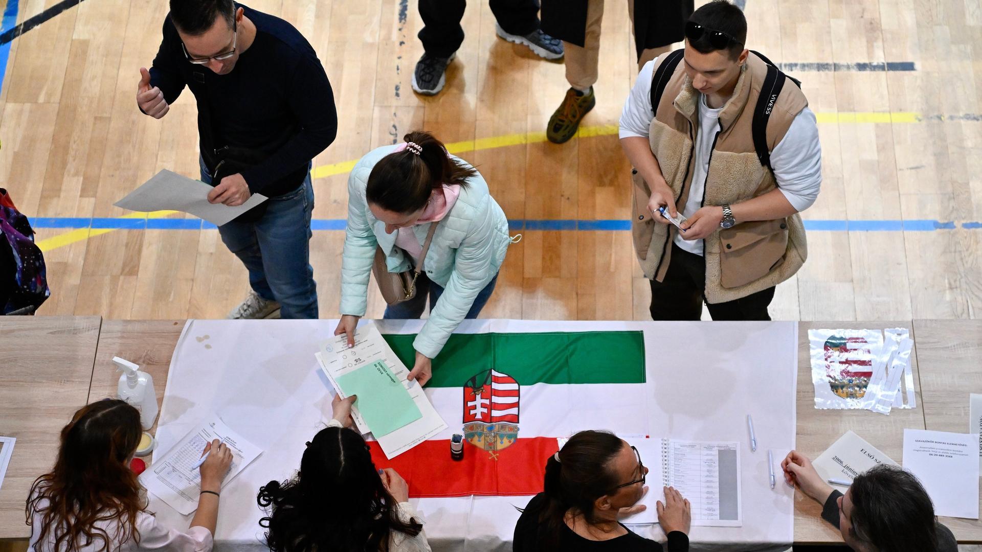 Aufnahme eines Wahllokals in Budapest während der ungarischen Parlamentswahlen: Eine Frau nimmt Stimmzettel entgegen. 