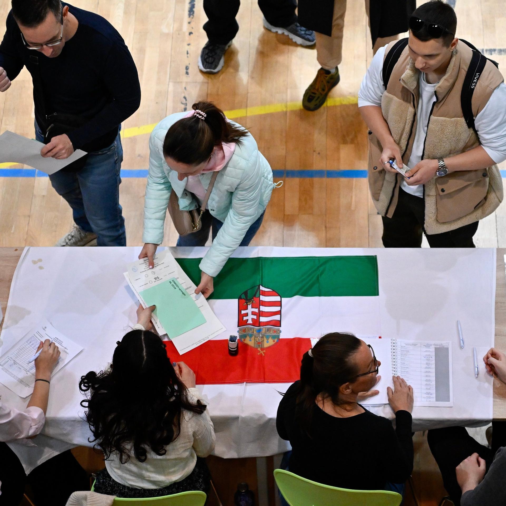 Aufnahme eines Wahllokals in Budapest während der ungarischen Parlamentswahlen: Eine Frau nimmt Stimmzettel entgegen. 