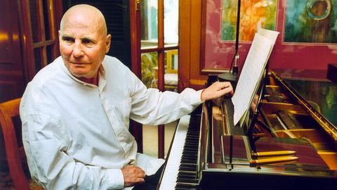 Der Komponist Hans Werner Henze sitzt am Klavier in seiner Wohnung