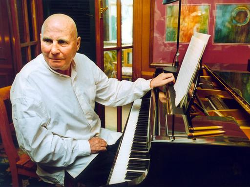 Der Komponist Hans Werner Henze sitzt am Klavier in seiner Wohnung