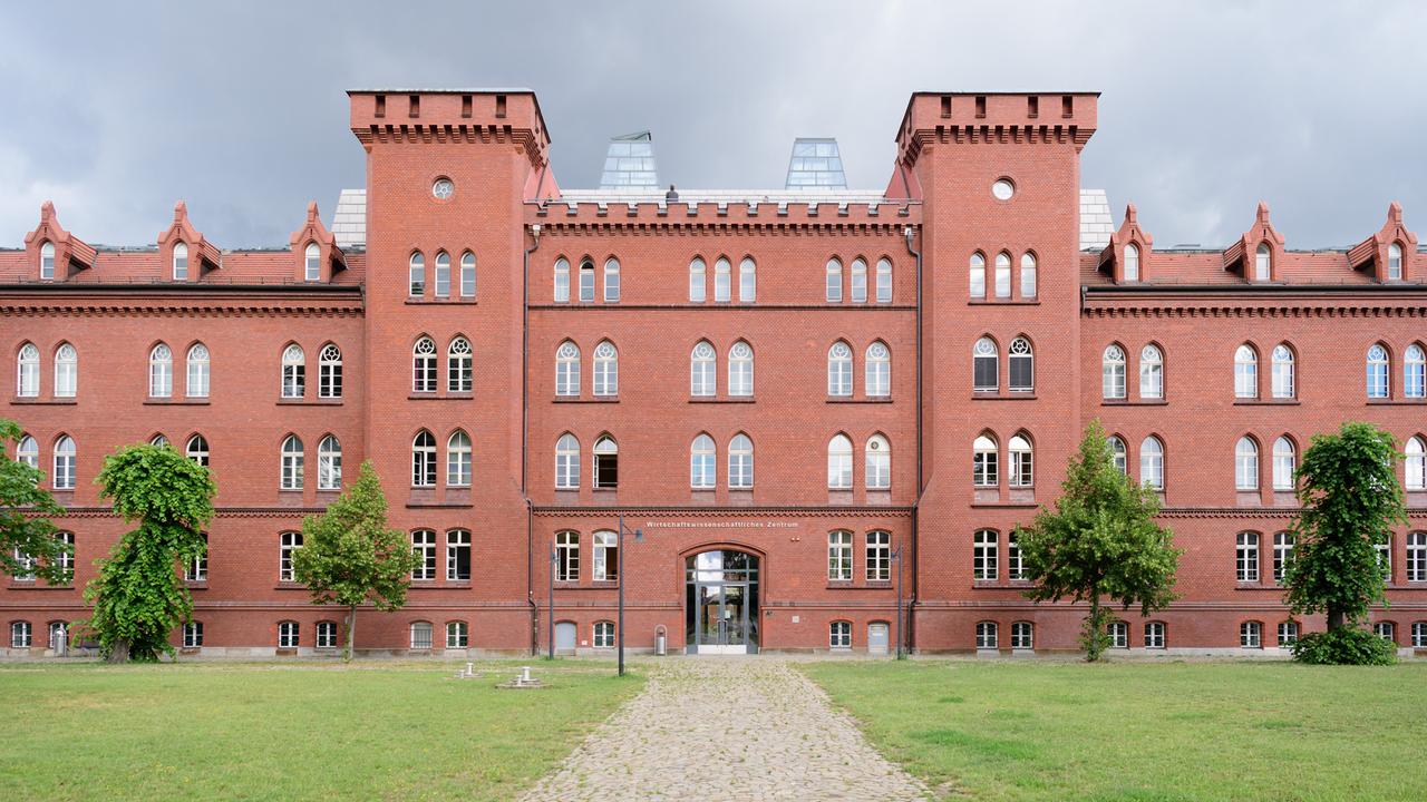 Ein Gebäude der Technischen Hochschule Brandenburg mit einer roten Fassade und zwei turmartigen Gebilden.