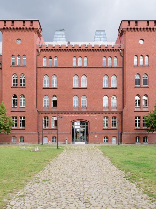 Ein Gebäude der Technischen Hochschule Brandenburg mit einer roten Fassade und zwei turmartigen Gebilden.