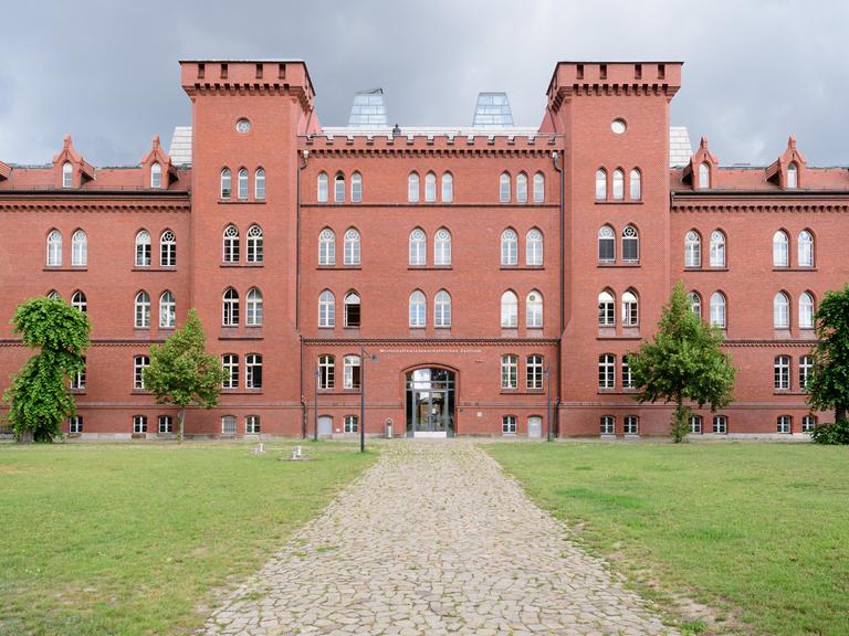 Ein Gebäude der Technischen Hochschule Brandenburg mit einer roten Fassade und zwei turmartigen Gebilden.