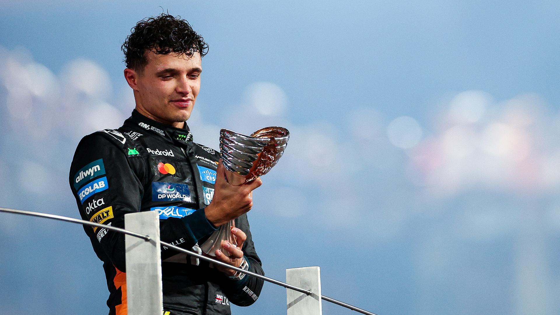 Renn-Fahrer schaut zärtlich auf seinen WM-Pokal Renn-Fahrer schaut zärtlich auf seinen WM-Pokal