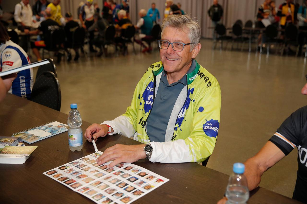 Ex-Radsport-Manager Hans-Michael Holczer wohnt einer Autogrammstunde bei.