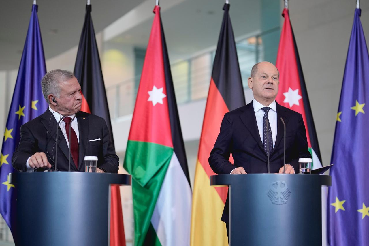 Bundeskanzler Scholz und der jordanische König Abdullah II. stehen jeweils hinter Rednerpulten. Hinter ihnen stehen die EU-, die jordanische und die deutsche Flagge.