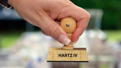 Hand mit Stempel und der Aufschrift: Hartz IV