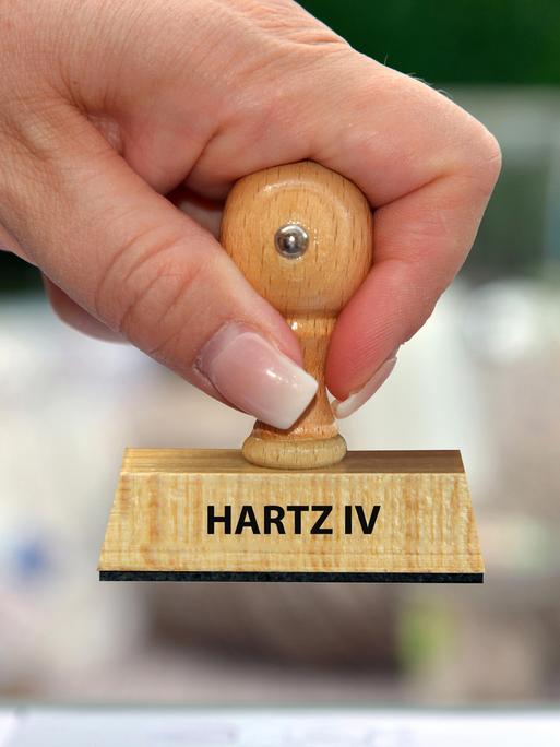 Hand mit Stempel und der Aufschrift: Hartz IV