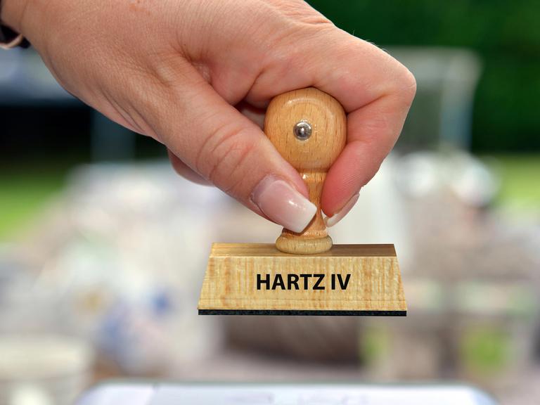 Hand mit Stempel und der Aufschrift: Hartz IV