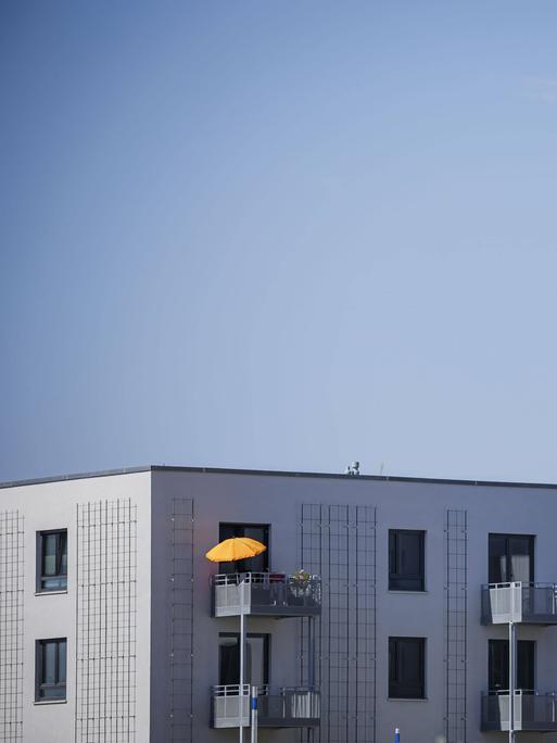 Blick auf das neu gebaute Stadtquartier Buckower Felder am suülichen Stadtrand von Berlin. Auf der etwa 16 Hektar grossen Flaeche entstehen ca. 900 Wohnungen. Ein Sonnenschirm steht auf dem Balkon einer bereits bezogenen Neubauwohnung.