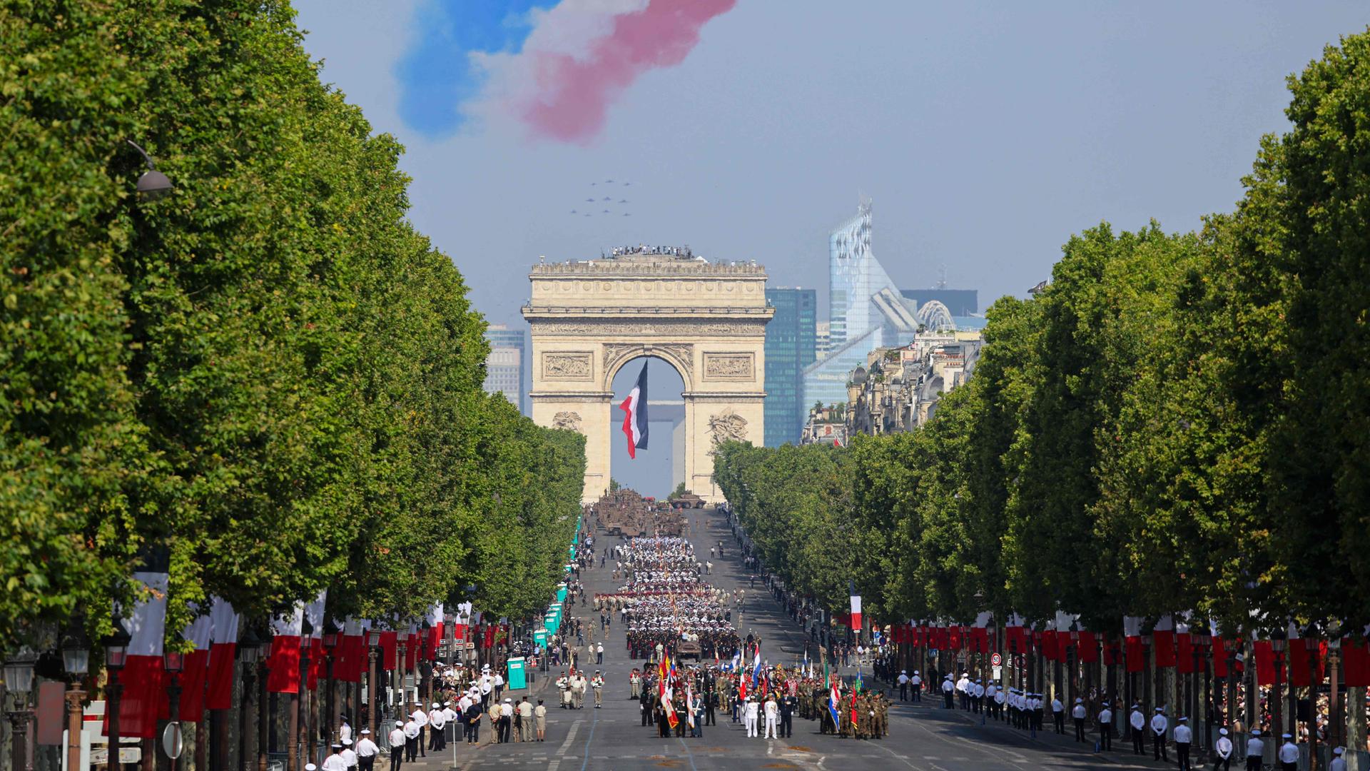 Frankreichs Elite-Kunstflugstaffel "Patrouille de France" hinterlässt Kondensstreifen in den französischen Nationalfarben, während sie bei der traditionellen Militärparade zum französischen Nationalfeiertag auf den Champs-Élysées den Triumphbogen überfliegt.