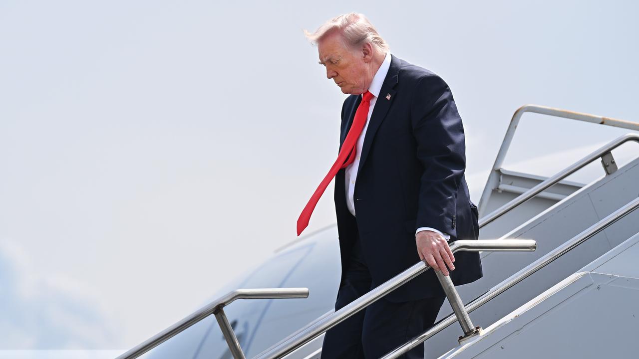 US-Präsident Donald Trump trifft am 1. Mai 2026 auf einem Flughafen in Florida, ein. Er hält sich am Handlauf der Treppe fest und geht vorsichtig herunter.