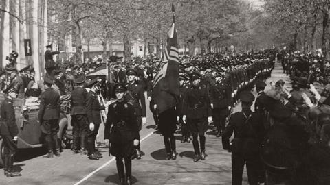 Nationaal-Socialistische Beweging (NSB), faschistische, später nationalsozialistische Partei in den Niederlanden, aktiv 1931 bis 1945 bei einer Parade im Jahr 1941. Vorne geht jemand mit einer Fahen. Im Hintergrund sind Bäume zu sehen.