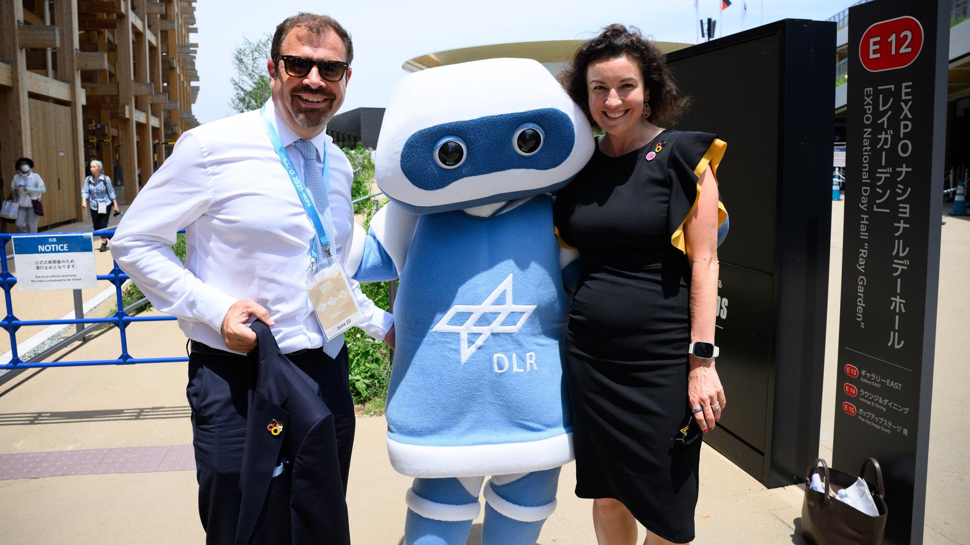 Osaka: Florian Hahn (l, CSU), Staatsminister im Auswärtigen Amt, und Dorothee Bär (CSU), Bundesministerin für Forschung, Technologie und Raumfahrt, lassen sich bei der Expo 2025 mit Arti, dem Maskottchen des DLR fotografieren. 