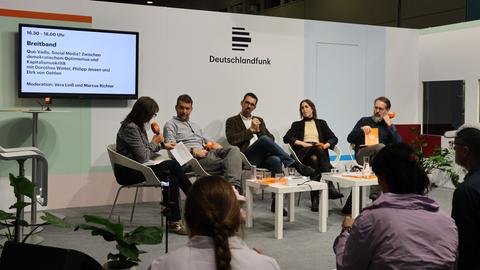 Gesprächsrunde von Deutschlandradio während der Buchmesse Frankfurt. Auf einer kleinen Bühne sitzen mehrere Personen und sprechen vor Publikum. Gesprächsrunde von Deutschlandradio während der Buchmesse Frankfurt. Auf einer kleinen Bühne sitzen mehrere Personen und sprechen vor Publikum.