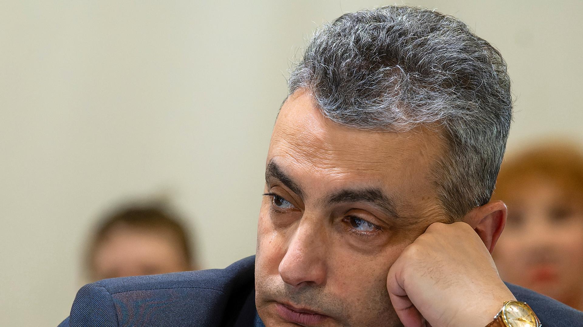 Der russische Oppositionspolitiker Lew Schlosberg stützt seinen Kopf und schaut nachdenklich. 