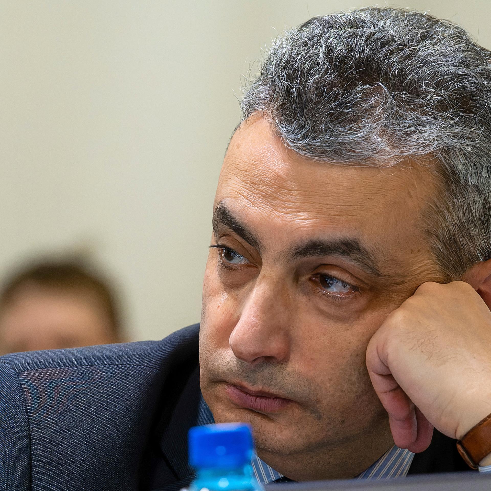 Der russische Oppositionspolitiker Lew Schlosberg stützt seinen Kopf und schaut nachdenklich. 