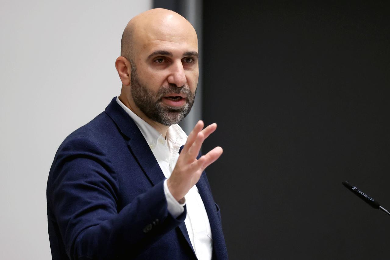 Der Psychologe Ahmad Mansour mit Halbglatze und Vollbart, in weißem Hemd und dunklem Jacket bei einem Vortrag