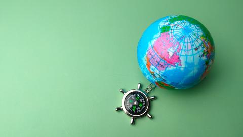 Ein Spielzeug-Kompass und eine kleine Weltkugel sind mit einer Kette verbunden