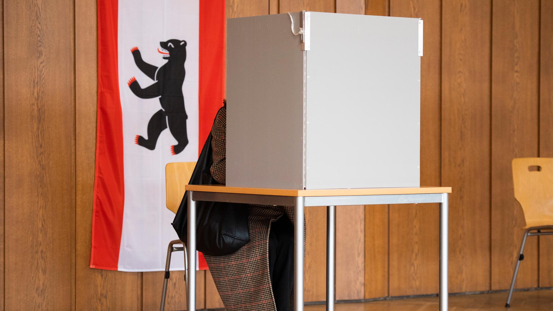 In einem Wahllokal hängt neben einer Wahlkabine eine Berlin-Flagge. In einem Wahllokal hängt neben einer Wahlkabine eine Berlin-Flagge.