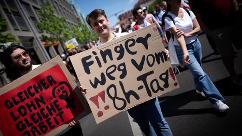 Demonstranten halten Plakate hoch: "Finger weg vom 8-Stunden-Tag" und "Gleicehr Lohn für gleiche Arbeit". 