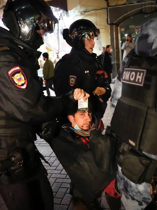 Polizisten tragen einen Demonstranten während einer Demonstration gegen die Mobilisierung in Moskau weg.