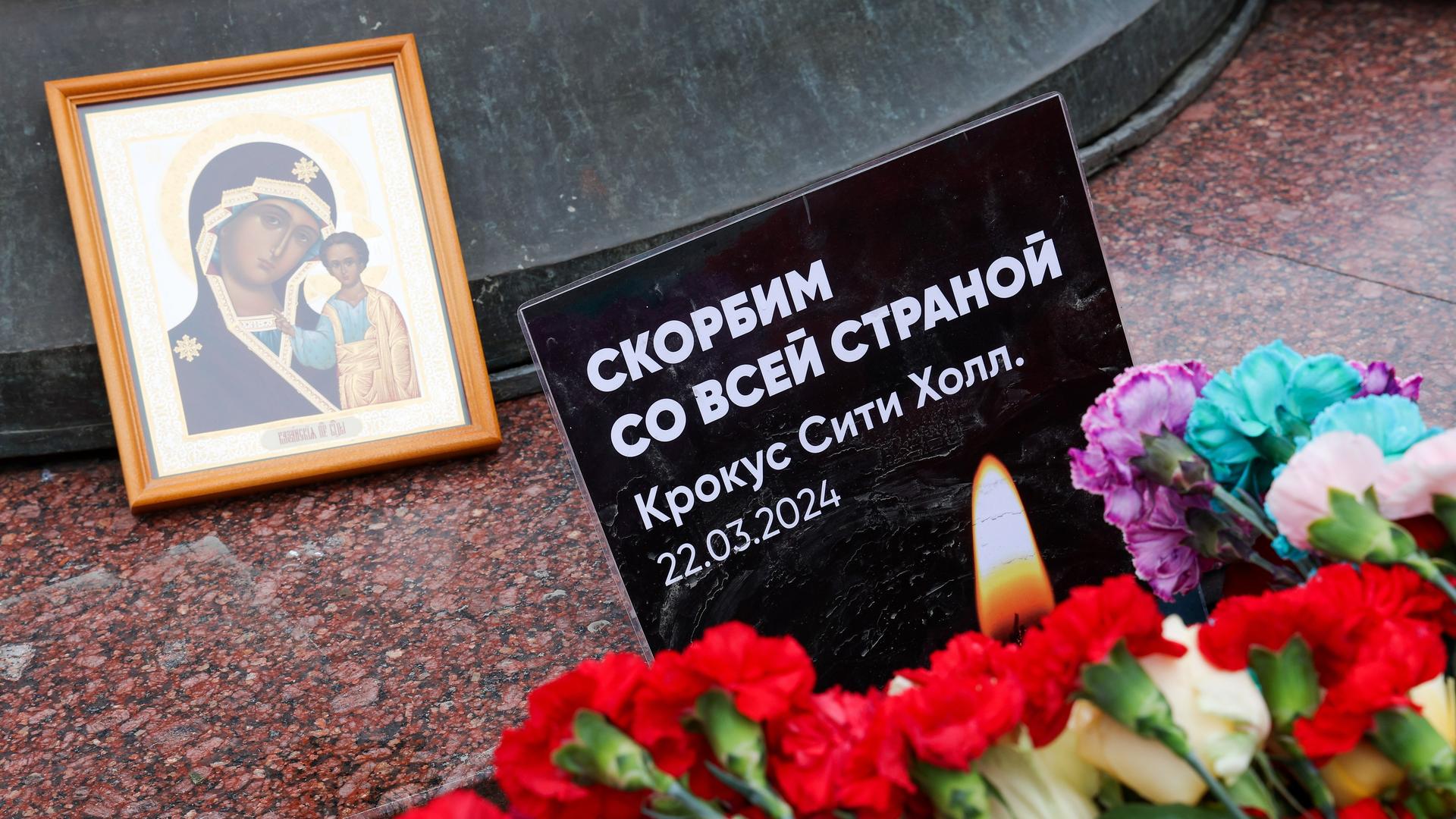 Ein Heiligenbild von Maria, Blumen und eine Gedenkschrift für die Opfer des Terroranschlags in der Crocus City Hall nahe Moskau. DIESES FOTO WIRD VON DER RUSSISCHEN STAATSAGENTUR TASS ZUR VERFÜGUNG GESTELLT. 