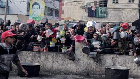 Palästinensische Gebiete, Rafah: Palästinenser warten an einer Spendenstelle in einem Flüchtlingslager im südlichen Gazastreifen auf Lebensmittel.
