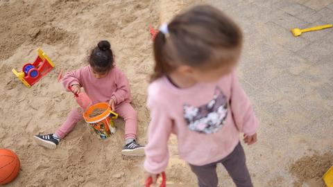 Zwei Kinder spielen draußen in einem Sandkasten in Berlin. (Symbolbild)
