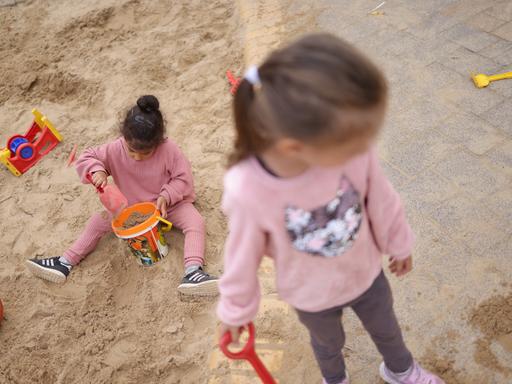 Zwei Kinder spielen draußen in einem Sandkasten in Berlin. (Symbolbild)