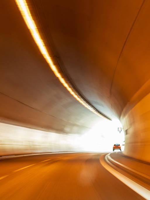 Ein Auto fährt durch einen Straßentunnel - am Ende ist das Licht sichtbar