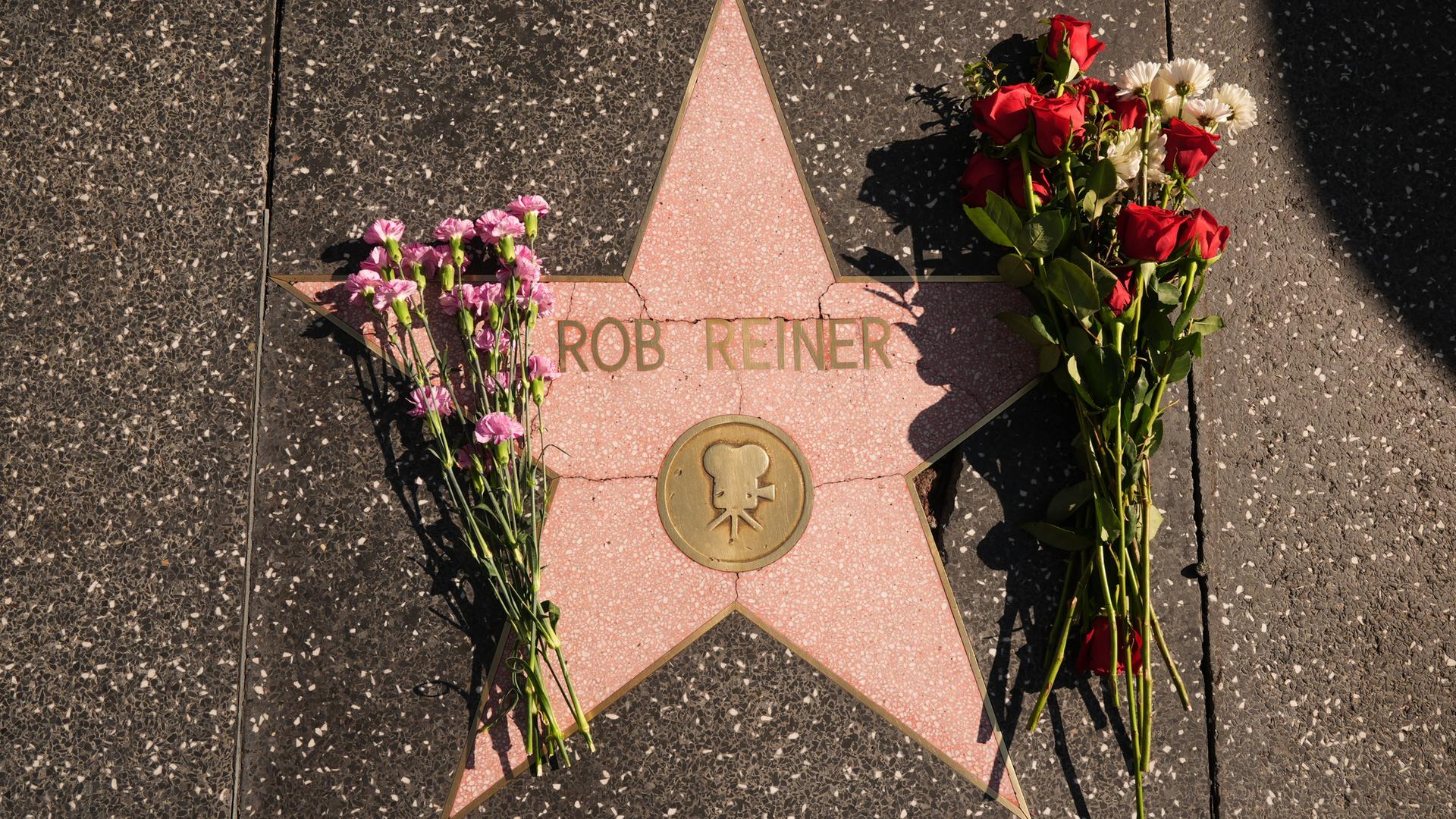 Nahaufnahme des Sterns auf dem Bürgersteig, an dem rechts und links zwei Blumenstäuße liegen. Nahaufnahme des Sterns auf dem Bürgersteig, an dem rechts und links zwei Blumenstäuße liegen.