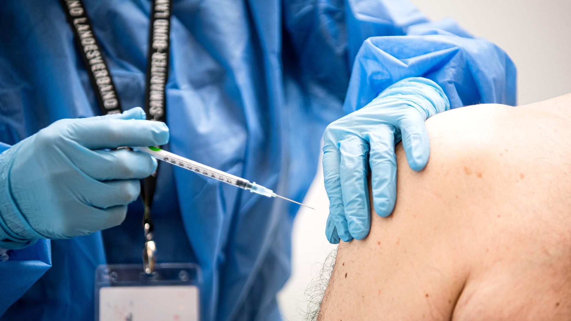 Ein Mann wird in einem Impfzentrum mit dem neuen Spikevax Impfstoff von Moderna geimpft