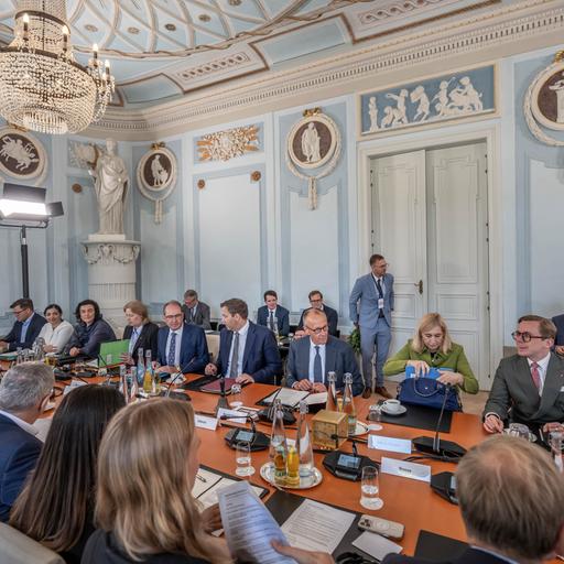 Bundeskanzler Friedrich Merz nimmt zwischen Lars Klingbeil und Nina Warken an der Kabinettssitzung bei der Klausurtagung der Bundesregierung in Schloss Neuhardenberg teil. 