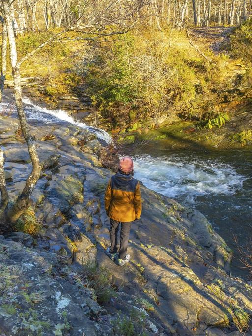 Wanderer bewundert den Zaldibartxo Wasserfall im Naturpark Gorbeia, Baskenland, einer wunderschönen Naturlandschaft in Nordspanien || Modellfreigabe vorhanden. Wanderer bewundert den Zaldibartxo Wasserfall im Naturpark Gorbeia, Baskenland, einer wunderschönen Naturlandschaft in Nordspanien || Modellfreigabe vorhanden.