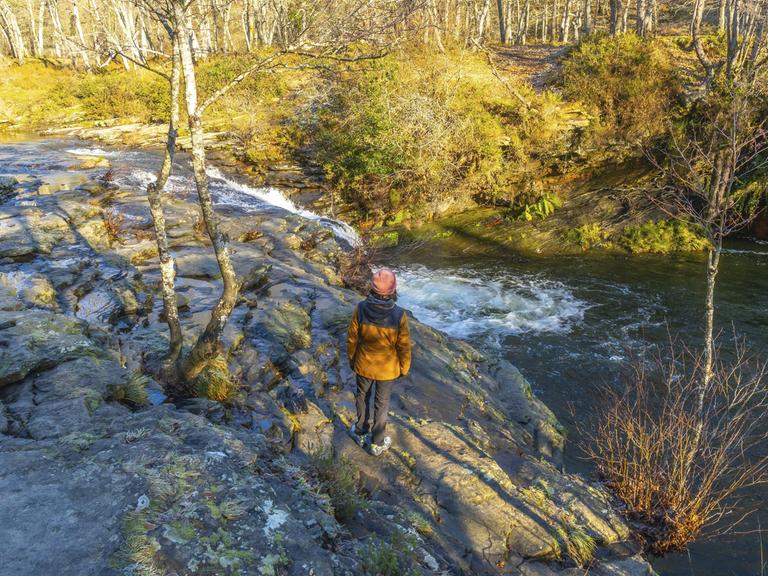 Wanderer bewundert den Zaldibartxo Wasserfall im Naturpark Gorbeia, Baskenland, einer wunderschönen Naturlandschaft in Nordspanien || Modellfreigabe vorhanden. Wanderer bewundert den Zaldibartxo Wasserfall im Naturpark Gorbeia, Baskenland, einer wunderschönen Naturlandschaft in Nordspanien || Modellfreigabe vorhanden.