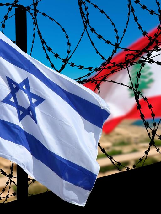 Die israelische und die libanesische Flagge wehen an einer Grenzanlage mit Stacheldraht.