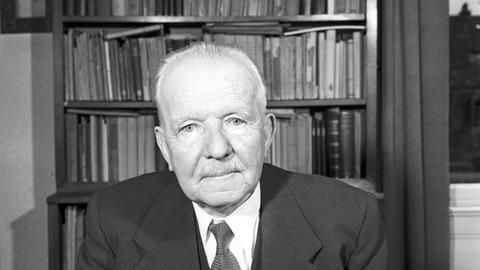 Schwarzweiß Porträt-Foto eines Mannes vor Bücherwand