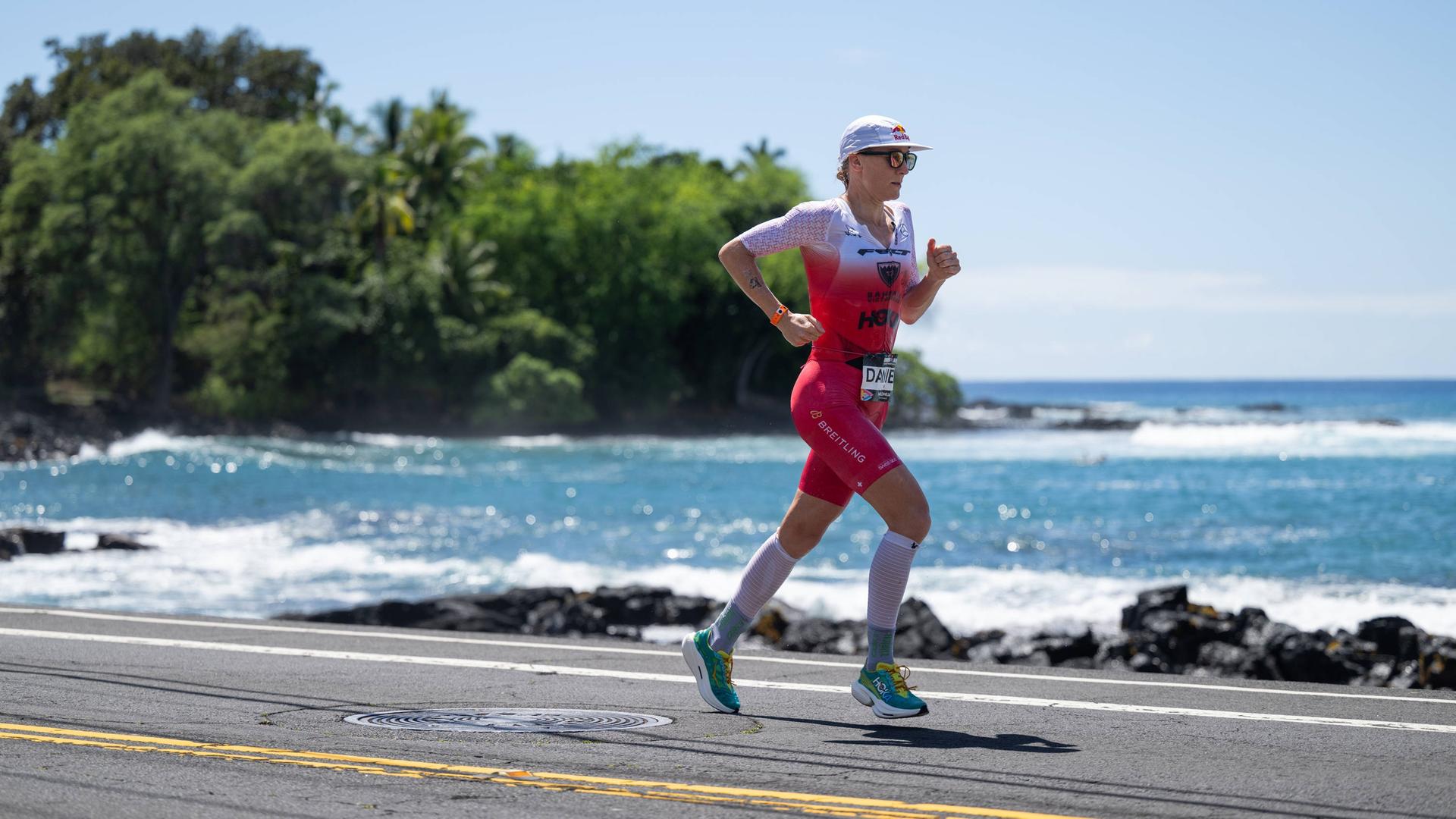 Ironman-Weltmeisterin Daniela Ryf läuft in Hawaii 2023 bei einem Wettbewerb auf einer Straße am Meer entlang.