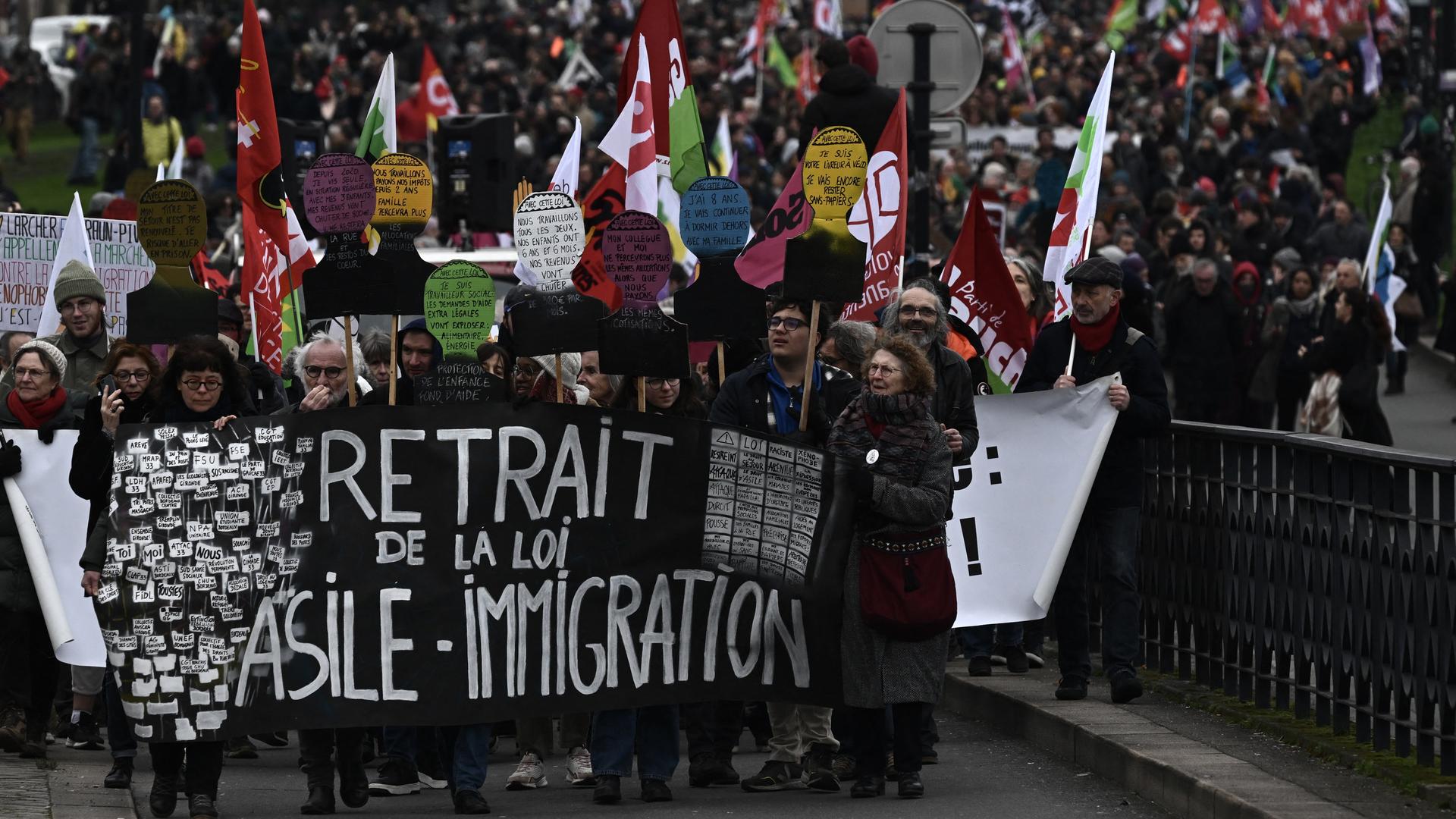 Demonstranten marschieren hinter einem Transparent mit der Aufschrift "Rücknahme des Asyl- und Einwanderungsgesetzes" während einer Kundgebung in Bordeaux am 21. Januar 2024.