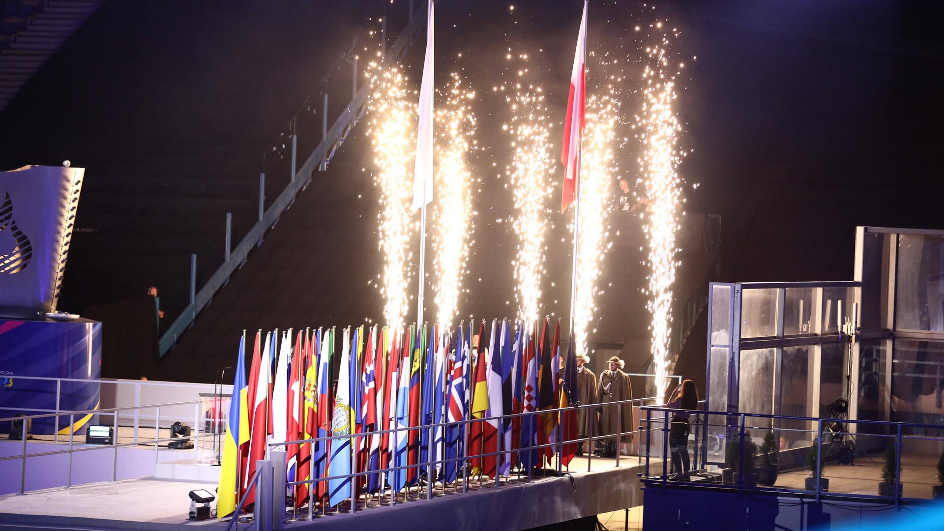 Die Eröffnungs-Feier von den Europa-Spielen: Verschiedene National-Fahnen sind zu sehen und Feuer-Werk.