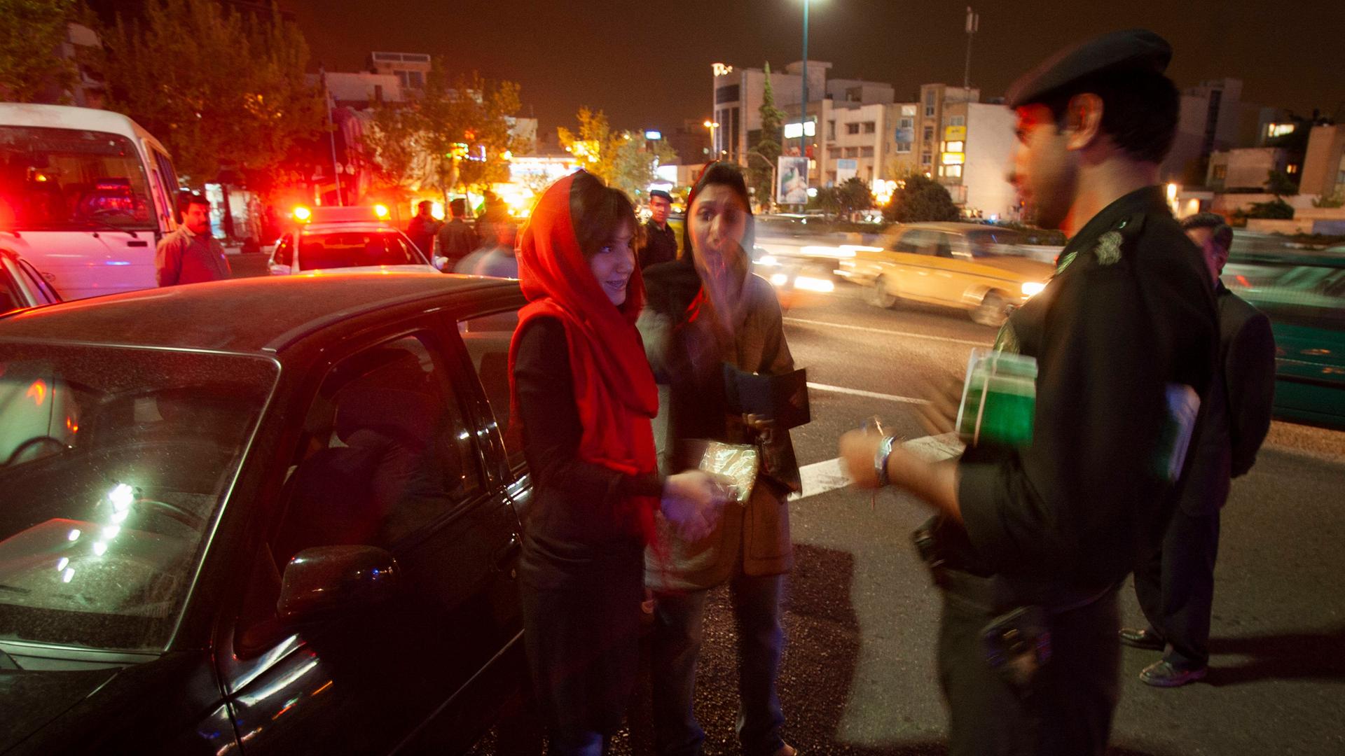Zu sehen sind Angehörige der Sittenpolizei bei einer Kontrolle von Frauen in Teheran.